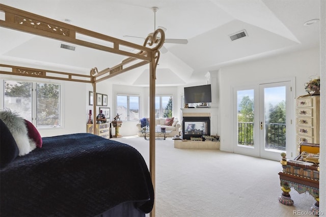 bedroom featuring carpet flooring, a multi sided fireplace, visible vents, multiple windows, and access to exterior