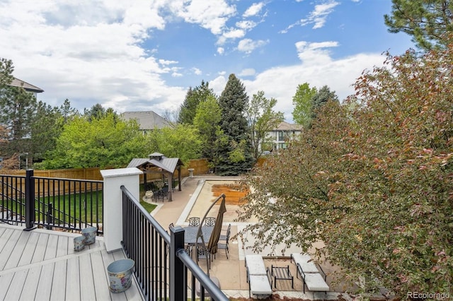 wooden terrace featuring a gazebo, fence, a patio, and outdoor dining area