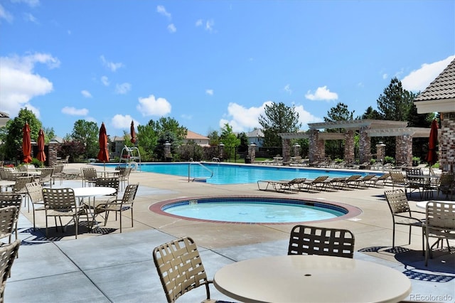 pool with a pergola, a patio, a community hot tub, and outdoor dining area