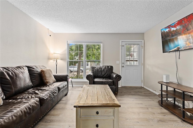 living room featuring light hardwood / wood-style floors and a textured ceiling