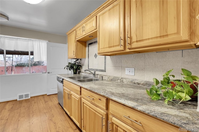 kitchen with light brown cabinets, sink, stainless steel dishwasher, light hardwood / wood-style floors, and light stone counters