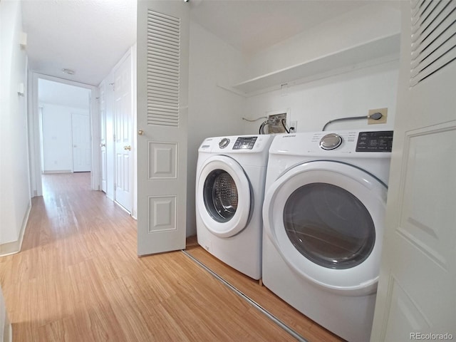 laundry area featuring separate washer and dryer and light wood-type flooring