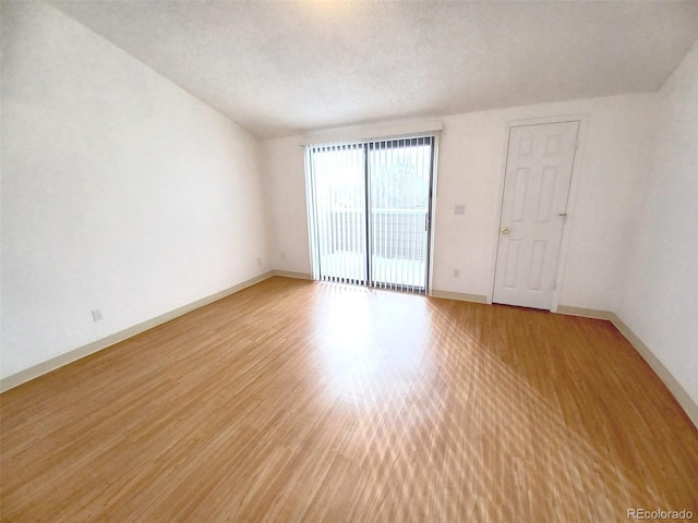 empty room with hardwood / wood-style floors and a textured ceiling