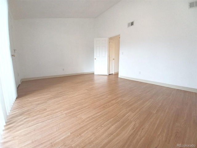 unfurnished room featuring light hardwood / wood-style flooring and high vaulted ceiling