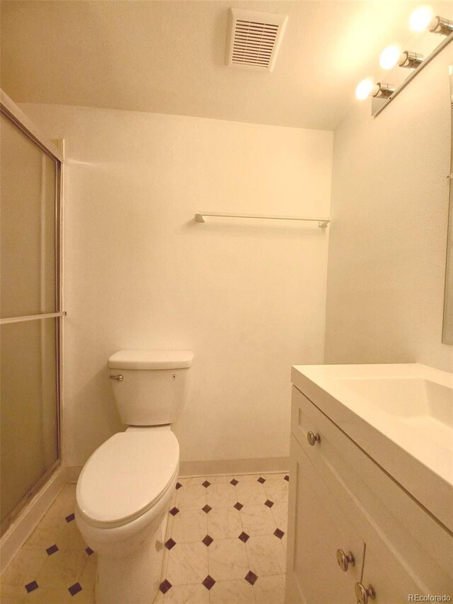 bathroom featuring vanity, toilet, and an enclosed shower