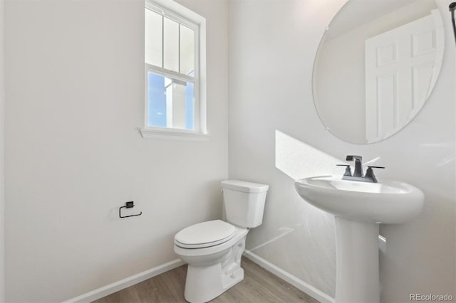 bathroom with toilet and hardwood / wood-style floors