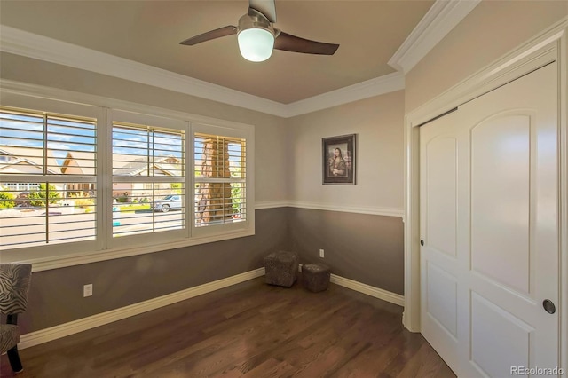 empty room featuring crown molding, baseboards, a ceiling fan, and dark wood finished floors