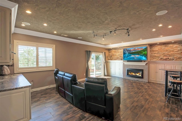 living area with recessed lighting, crown molding, dark wood-type flooring, and a glass covered fireplace