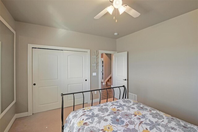 bedroom featuring a closet, baseboards, a ceiling fan, and light colored carpet
