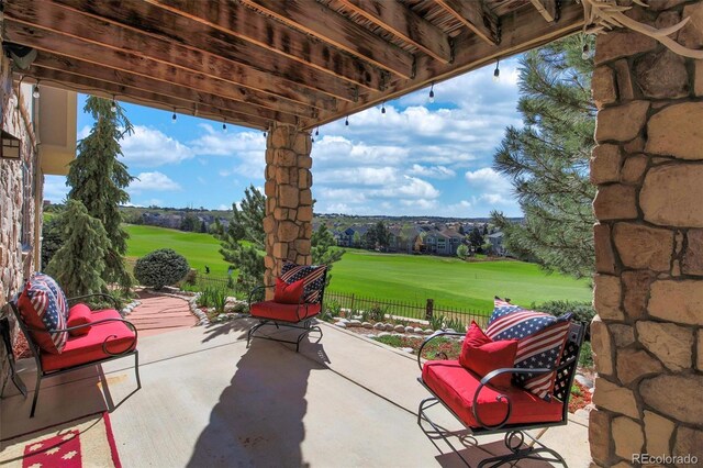 view of patio / terrace featuring view of golf course and fence