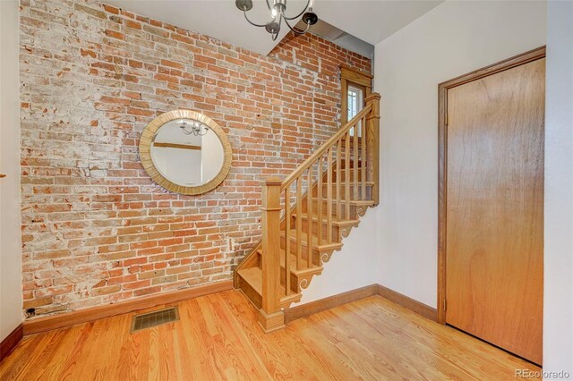 458 S Downing St, Denver, CO 80209 - stairs featuring brick wall, wood finished floors, and baseboards