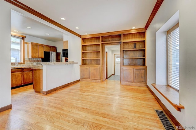 458 S Downing St, Denver, CO 80209 - kitchen featuring ornamental molding, freestanding refrigerator, light wood-style flooring, light countertops, and brown cabinets