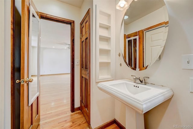 458 S Downing St, Denver, CO 80209 - bathroom featuring wood finished floors, a sink, built in features, and baseboards