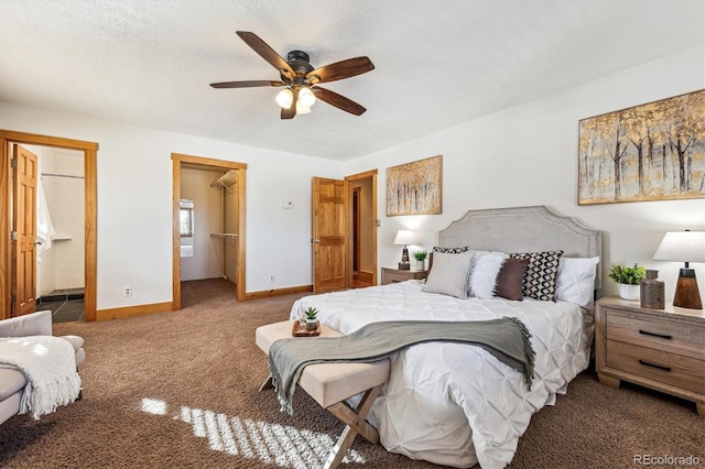 bedroom with a spacious closet, carpet floors, a textured ceiling, and ensuite bathroom