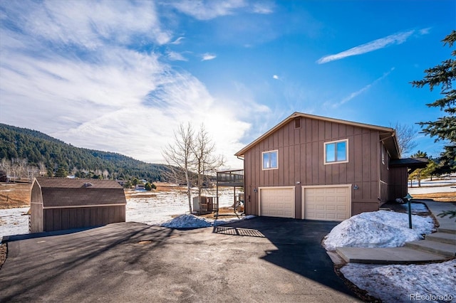 view of side of property with a mountain view and a garage