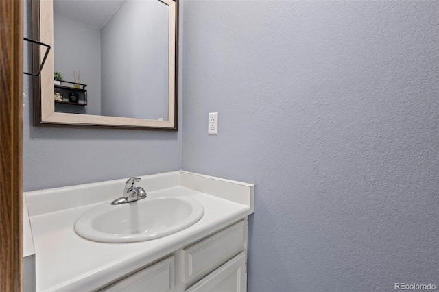 bathroom featuring a textured wall and vanity