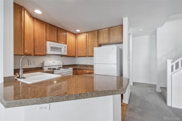 kitchen featuring white appliances, sink, kitchen peninsula, and light colored carpet