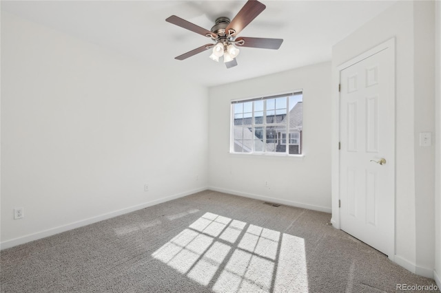 carpeted spare room featuring ceiling fan