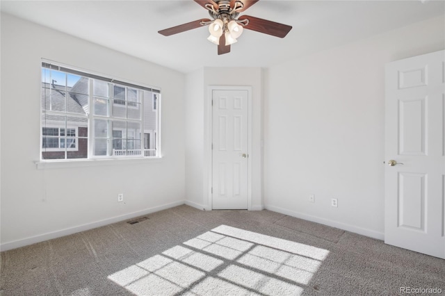 carpeted spare room with ceiling fan