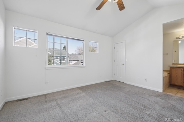 spare room with lofted ceiling, light carpet, a healthy amount of sunlight, and ceiling fan