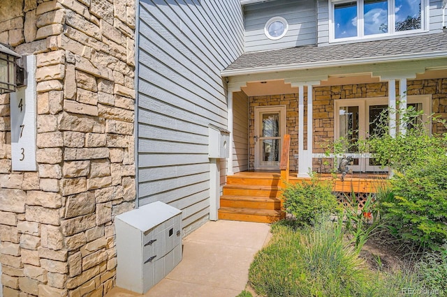 8505 E Temple Dr Unit 473, Denver, CO 80237 - view of exterior entry featuring a shingled roof, covered porch, and stone siding