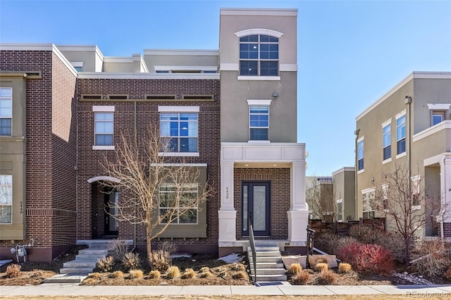 view of front of property with brick siding and stucco siding