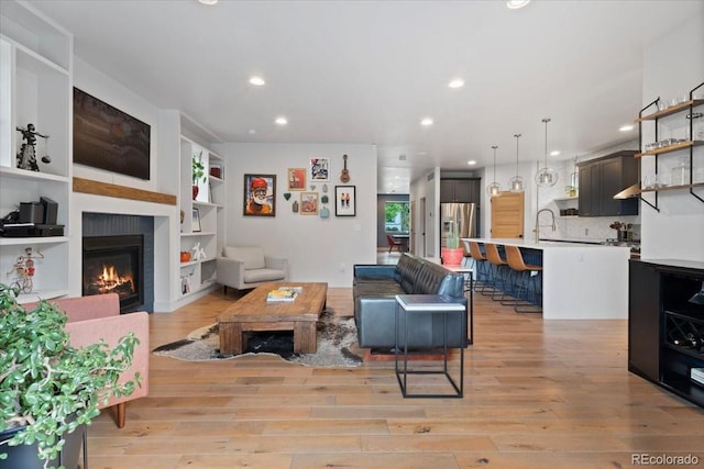 2533 N Emerson St, Denver, CO 80205 - living area featuring light wood-style floors, recessed lighting, a glass covered fireplace, and built in features