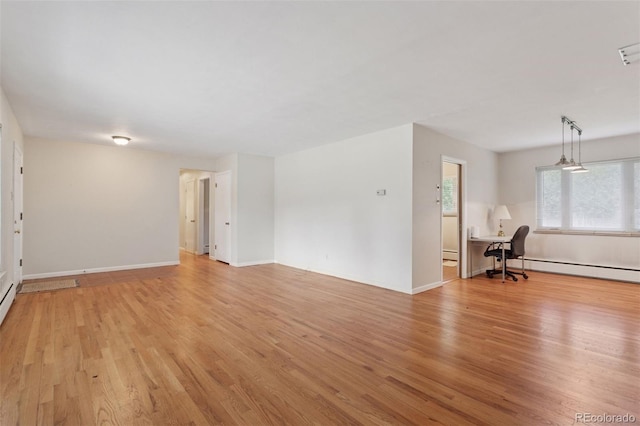 3030 S University Blvd, Denver, CO 80210 - unfurnished living room with light wood-type flooring, a desk, healthy amount of natural light, and baseboard heating