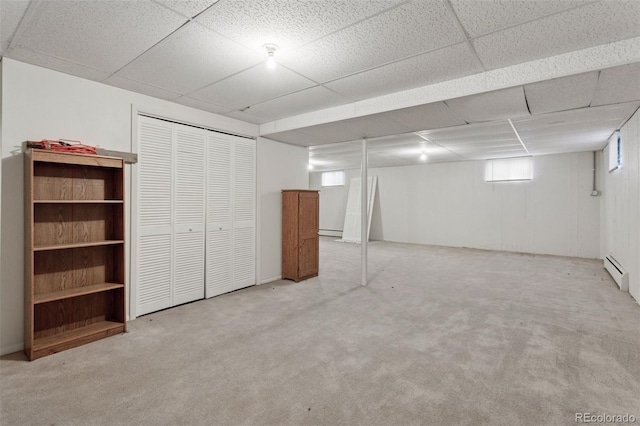 3030 S University Blvd, Denver, CO 80210 - below grade area with light carpet, baseboard heating, a paneled ceiling, and a baseboard heating unit