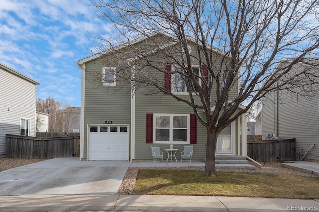 view of front of home with driveway, an attached garage, and fence