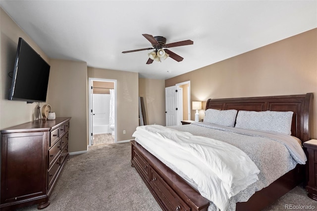 carpeted bedroom with connected bathroom, baseboards, and a ceiling fan