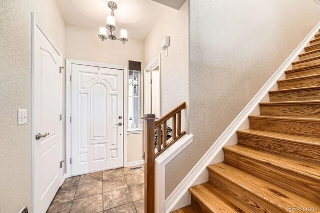 11839 E Fair Ave, Greenwood Village, CO 80111 - entryway featuring stairway, a chandelier, and a textured wall