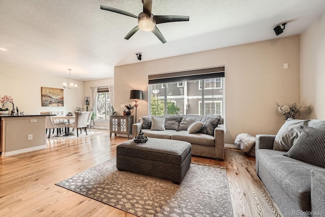 11839 E Fair Ave, Greenwood Village, CO 80111 - living area featuring a chandelier, light wood-type flooring, ceiling fan, and a textured ceiling