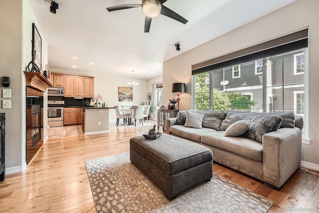 11839 E Fair Ave, Greenwood Village, CO 80111 - living room with a ceiling fan, a chandelier, and light wood-style floors