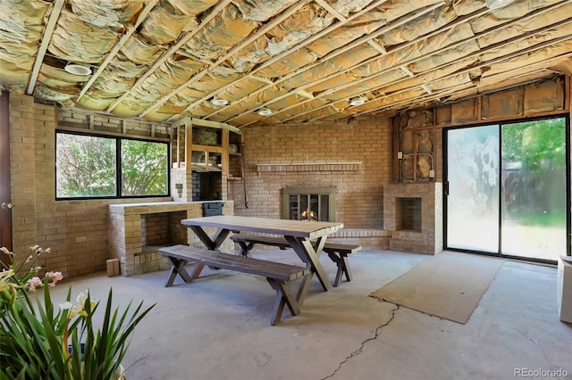 1803 Graves Ct, Northglenn, CO 80233 - living room with a fireplace, unfinished concrete flooring, and brick wall