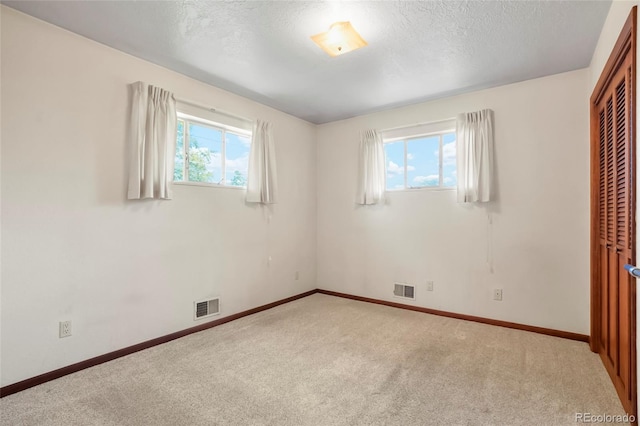 1803 Graves Ct, Northglenn, CO 80233 - unfurnished bedroom featuring multiple windows, a closet, carpet, and a textured ceiling
