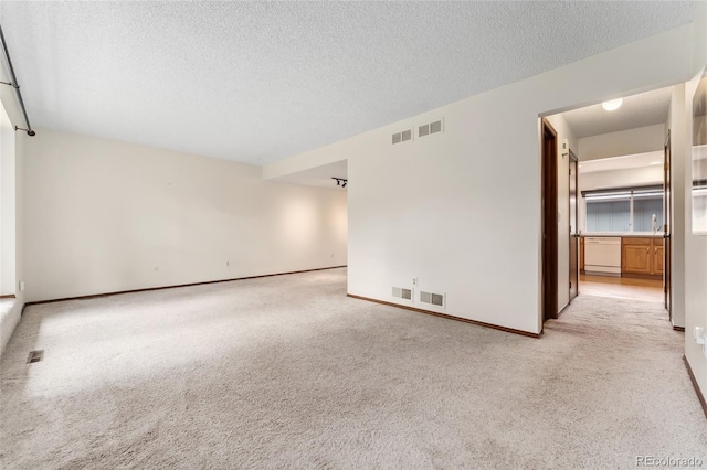 unfurnished room featuring light colored carpet, a textured ceiling, and visible vents