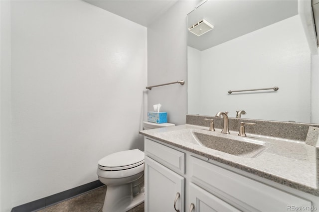 bathroom with vanity, tile patterned flooring, baseboards, and toilet