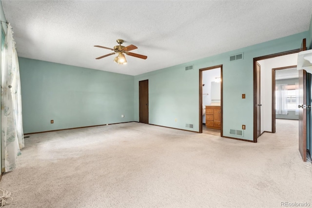 unfurnished bedroom with light carpet, a textured ceiling, and visible vents
