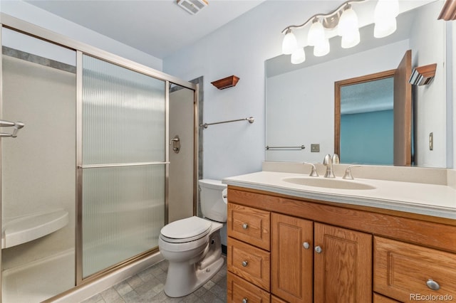 full bath featuring vanity, toilet, visible vents, and a stall shower