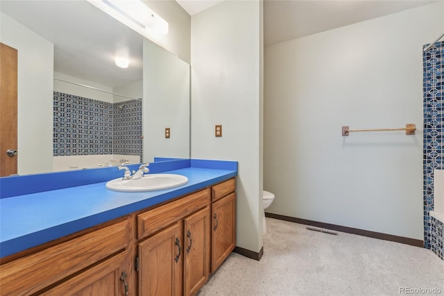 full bath featuring visible vents, a tile shower, vanity, baseboards, and toilet