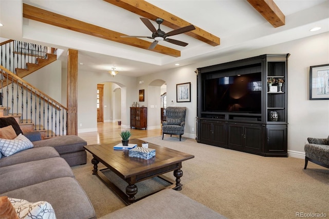 carpeted living room featuring beam ceiling and ceiling fan