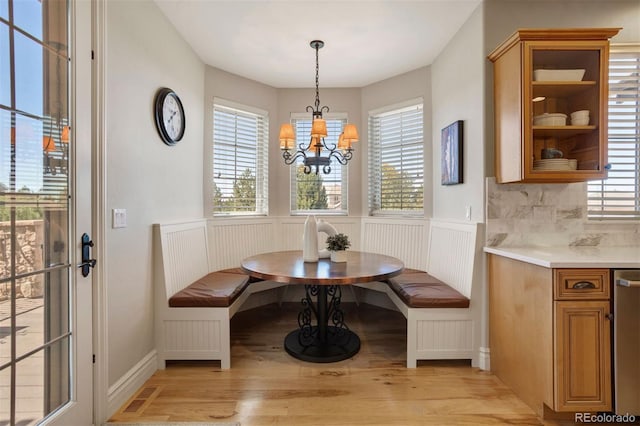 dining space with an inviting chandelier, light hardwood / wood-style floors, breakfast area, and plenty of natural light