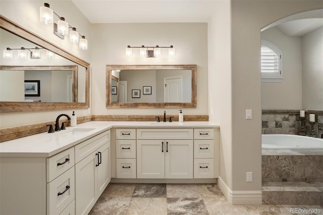 bathroom with tiled bath and vanity