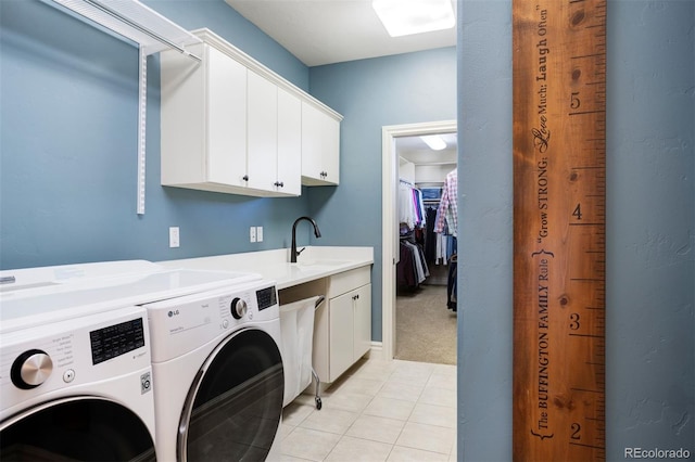 clothes washing area featuring light tile patterned floors, cabinets, sink, and washing machine and clothes dryer