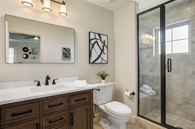 bathroom with tile patterned floors, a shower with shower door, ceiling fan, vanity, and toilet