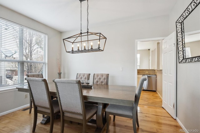 dining space featuring light wood-type flooring and an inviting chandelier