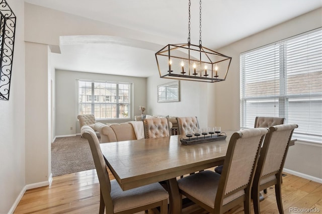 dining room with light hardwood / wood-style floors and a notable chandelier