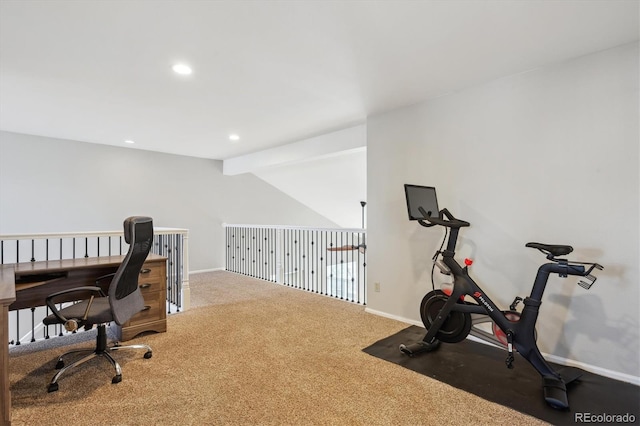 carpeted office space featuring vaulted ceiling with beams