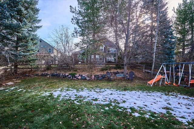 yard layered in snow featuring a playground